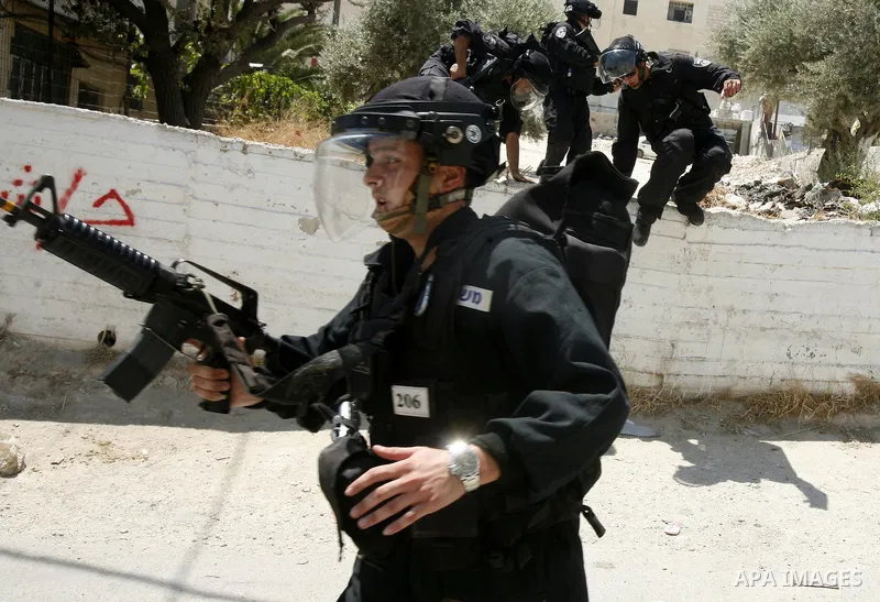 Israeli policemen run with their weapons during stormed in the West Bank town of Issawiya, in the West Bank, on Aug. 07, 2012. Photo by Mahfouz Abu Turk