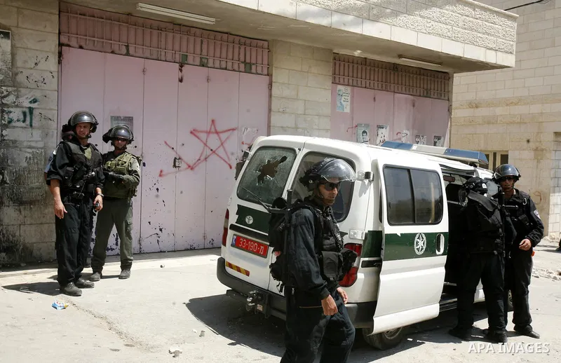 Israeli policemen run with their weapons during stormed in the West Bank town of Issawiya, in the West Bank, on Aug. 07, 2012. Photo by Mahfouz Abu Turk