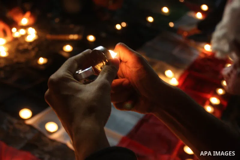 Palestinian youths light candles and place them on Palestinian and Egyptian flags on August 8, 2012, in the West Bank city of Ramallah, in memory of the 16 Egyptian soldiers who were killed in a militant ambush on August...