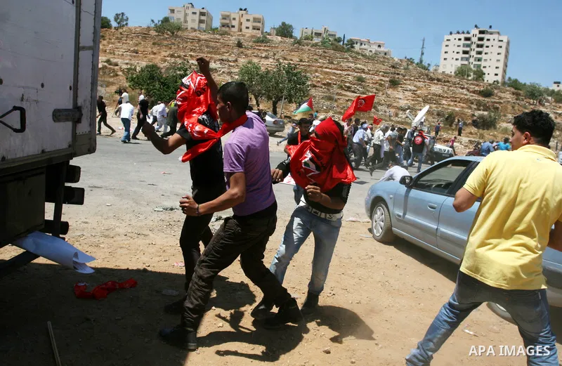 Palestinians hurl stones at Israeli troops, not seen, during a Democratic Front for the Liberation of Palestine (DFLP) demonstration supporting prisoners in Israeli jails outside the Ofer military prison, near the West B...