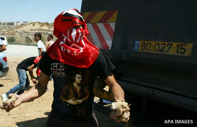 Palestinians hurl stones at Israeli troops, not seen, during a Democratic Front for the Liberation of Palestine (DFLP) demonstration supporting prisoners in Israeli jails outside the Ofer military prison, near the West B...
