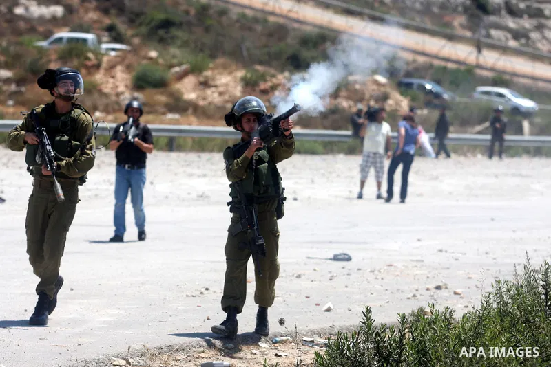 Israeli soldiers fire tear gas at Palestinian protestor during a Democratic Front for the Liberation of Palestine (DFLP) demonstration supporting prisoners in Israeli jails outside the Ofer military prison, near the West...