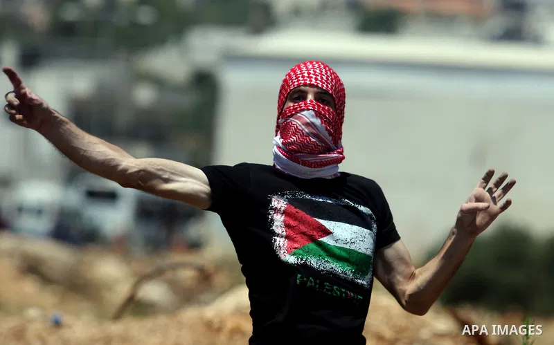 Palestinians hurl stones at Israeli troops, not seen, during a Democratic Front for the Liberation of Palestine (DFLP) demonstration supporting prisoners in Israeli jails outside the Ofer military prison, near the West B...