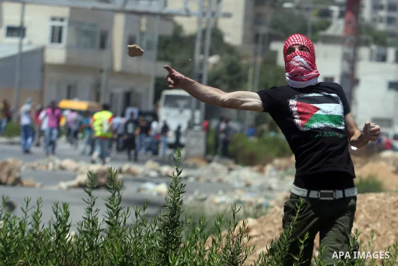Palestinians hurl stones at Israeli troops, not seen, during a Democratic Front for the Liberation of Palestine (DFLP) demonstration supporting prisoners in Israeli jails outside the Ofer military prison, near the West B...