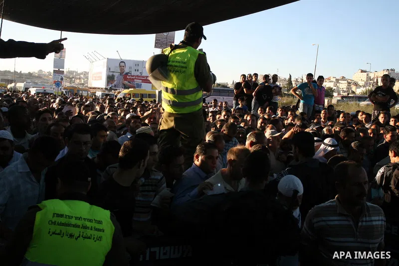 Israeli border police officers watch Palestinians crossing at the military checkpoint of Qalandia, North of Jerusalem, in the West Bank, 10 August 2012, on their way to Jerusalem to attend the Ramadan Friday Prayers in t...