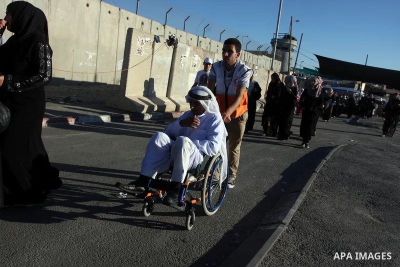Palestinians walkt in line next to the separation barrier to cross at the military checkpoint of Qalandia, North of Jerusalem, in the West Bank, 10 August 2012, on their way to Jerusalem to attend the Ramadan Friday Pray...
