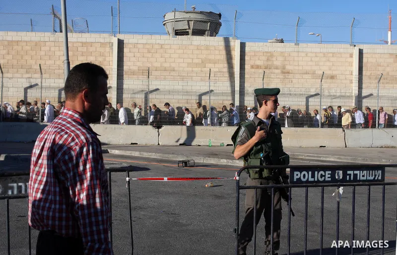 A Palestinian man walks past an Israeli border police officer during cross the military checkpoint of Qalandia, North of Jerusalem, in the West Bank, 10 August 2012, on their way to Jerusalem to attend the Ramadan Friday...