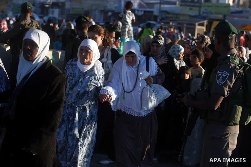 Israeli border police officers check Palestinian women ID while crossing at the military checkpoint of Qalandia, North of Jerusalem, in the West Bank, 10 August 2012, on their way to Jerusalem to attend the Ramadan Frida...