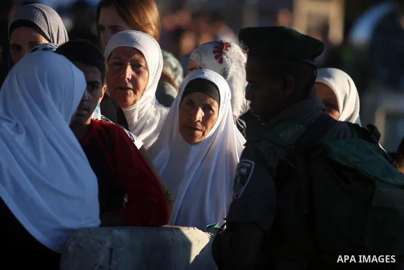 Israeli border police officers check Palestinian women ID while crossing at the military checkpoint of Qalandia, North of Jerusalem, in the West Bank, 10 August 2012, on their way to Jerusalem to attend the Ramadan Frida...