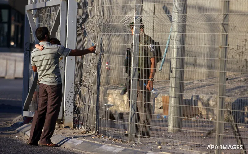 An Israeli border police officer checks A Palestinian man ID while crossing at the military checkpoint of Qalandia, North of Jerusalem, in the West Bank, 10 August 2012, on their way to Jerusalem to attend the Ramadan Fr...