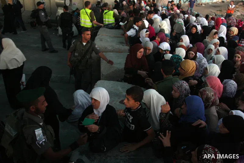 Israeli border police officers check Palestinian women ID while crossing at the military checkpoint of Qalandia, North of Jerusalem, in the West Bank, 10 August 2012, on their way to Jerusalem to attend the Ramadan Frida...