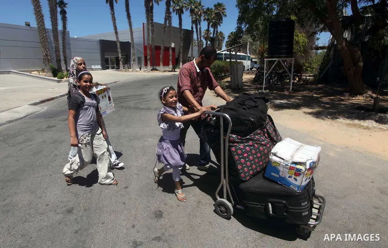 Palestinians return from Egypt cross into the southern Gaza Strip at the Rafah border crossing August 10, 2012. Egyptian military forces have captured six "terrorists" in the Sinai region after an attack on a police stat...
