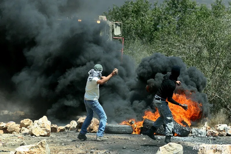 Palestinian protesters throw stones at Israeli bulldozer during a demonstration against the expropriation of Palestinian land by Israel in the village of Kafr Qaddum, near the West Bank city of Nablus, on August 10, 2012...