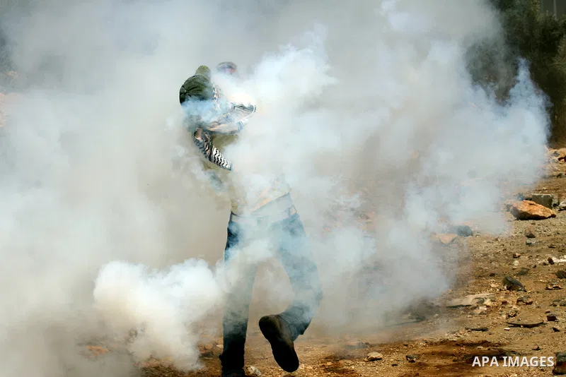 A Palestinian protester throws stones at Israeli bulldozer during a demonstration against the expropriation of Palestinian land by Israel in the village of Kafr Qaddum, near the West Bank city of Nablus, on August 10, 20...