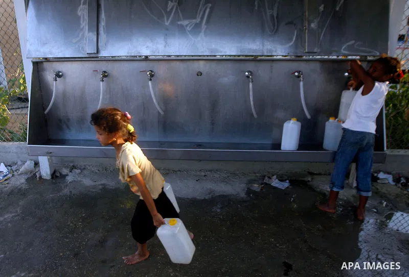 Palestinian children fill their bottles a potable water at a water purification station, in Rafah refugee camp southern Gaza Strip, on 11 August 2012. Palestinians suffer from the severe lack of potable water. Photo by E...