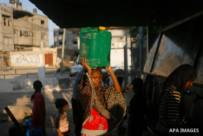 Palestinian children fill their bottles a potable water at a water purification station, in Rafah refugee camp southern Gaza Strip, on 11 August 2012. Palestinians suffer from the severe lack of potable water. Photo by E...