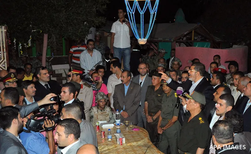 Newly elected Egyptian President Mohamed Mursi is flanked by Field Marshal Hussein Tantawi and Egyptian Armed Forces Chief of Staff Sami Anan as he talks to the soldiers at a checkpoint in al-Arish August 10, 2012. Egypt...