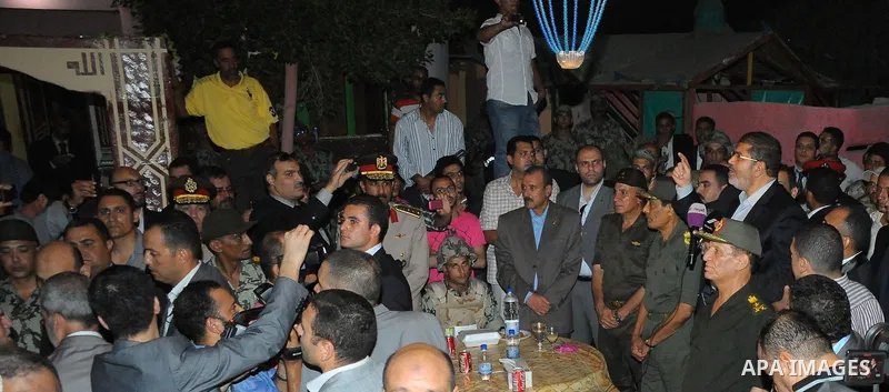 Newly elected Egyptian President Mohamed Mursi is flanked by Field Marshal Hussein Tantawi and Egyptian Armed Forces Chief of Staff Sami Anan as he talks to the soldiers at a checkpoint in al-Arish August 10, 2012. Egypt...