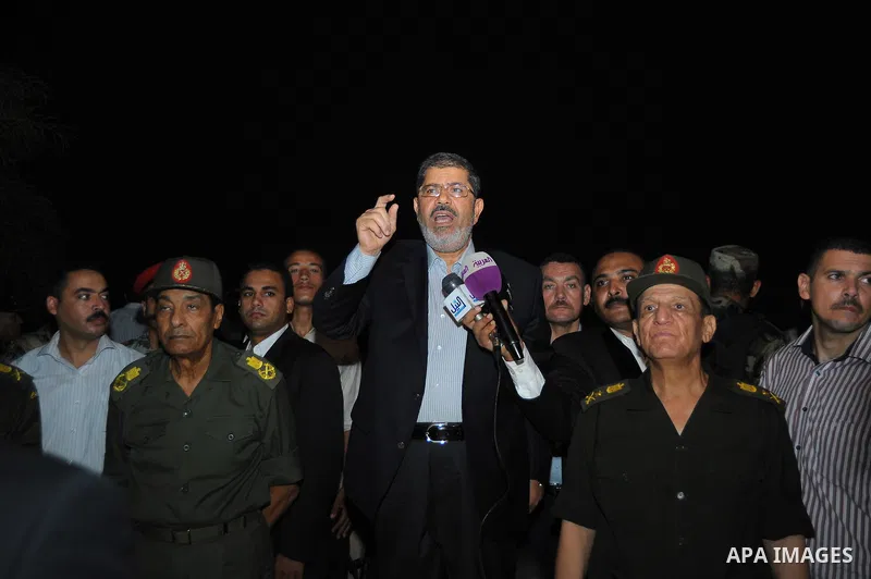 Newly elected Egyptian President Mohamed Mursi is flanked by Field Marshal Hussein Tantawi (L) and Egyptian Armed Forces Chief of Staff Sami Anan (R) as he talks to the soldiers at a checkpoint in al-Arish August 10, 201...
