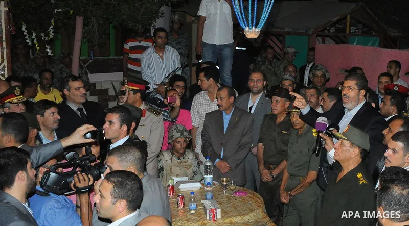 Newly elected Egyptian President Mohamed Mursi is flanked by Field Marshal Hussein Tantawi and Egyptian Armed Forces Chief of Staff Sami Anan as he talks to the soldiers at a checkpoint in al-Arish August 10, 2012. Egypt...