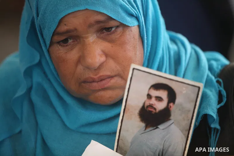 A Palestinian woman holds a picture of her relative prisoner in Israeli jails as she gather with Palestinians in an activity calling for their liberty at the Red Cross headquarters in Gaza City on 13 August 2012. Photo b...