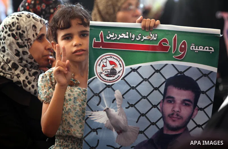A Palestinian girl holds a picture of her relative prisoner in Israeli jails as she gather with Palestinians in an activity calling for their liberty at the Red Cross headquarters in Gaza City on 13 August 2012. Photo by...