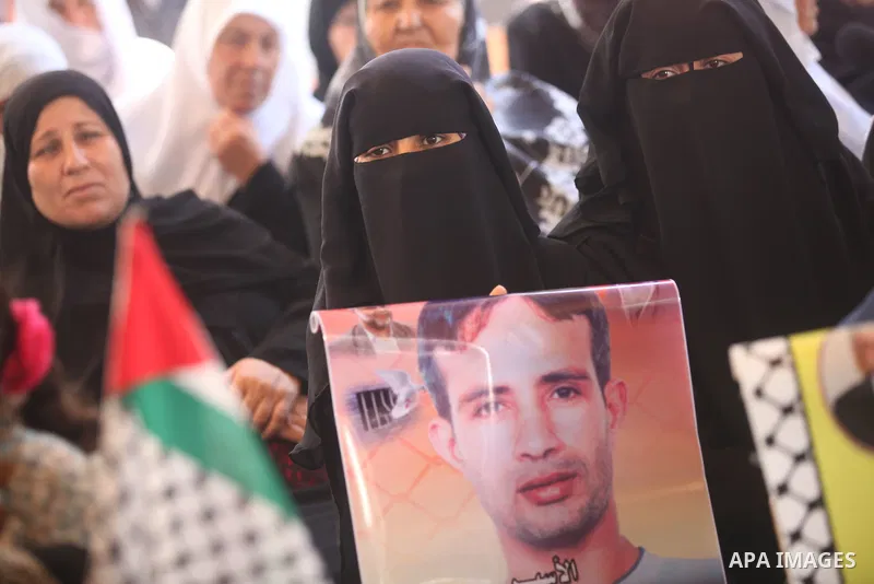 Palestinian women hold pictures of their relatives prisoners in Israeli jails as they gather in an activity calling for their liberty at the Red Cross headquarters in Gaza City on 13 August 2012. Photo by Majdi Fathi