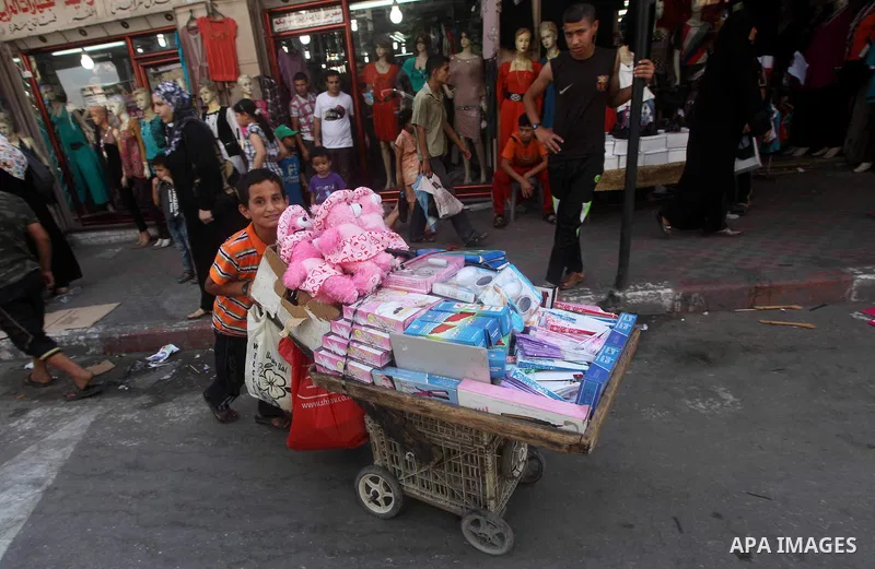 A Palestinian child sells toys at a market in Gaza city on Aug 13,2012, as Muslims over the world prepare to celebrate Eid al-Fitr, a three day holiday marking the end of the religious month of Ramadan in which believers...