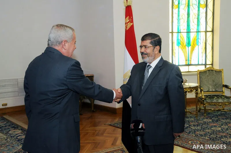 Egypt's President Mohamed Mursi (R) shakes hands with Egypt's newly appointed Minister of State for Military Production Reda Mahmoud Hafez Abdel Maguid at the presidential palace in Cairo, August 13, 2012. Mursi has driv...