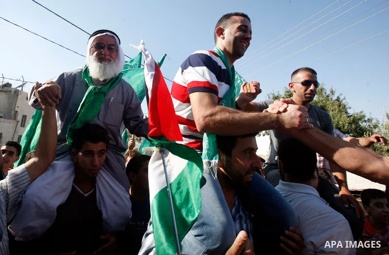 Palestinians celebrate after the Israeli authorities released prisoner Aws Ibrahim Hamada in neighborhood of Sour Baher in Jerusalem on Aug 13, 2012. Hamada spent 10 years in prison before the Israeli authorities release...