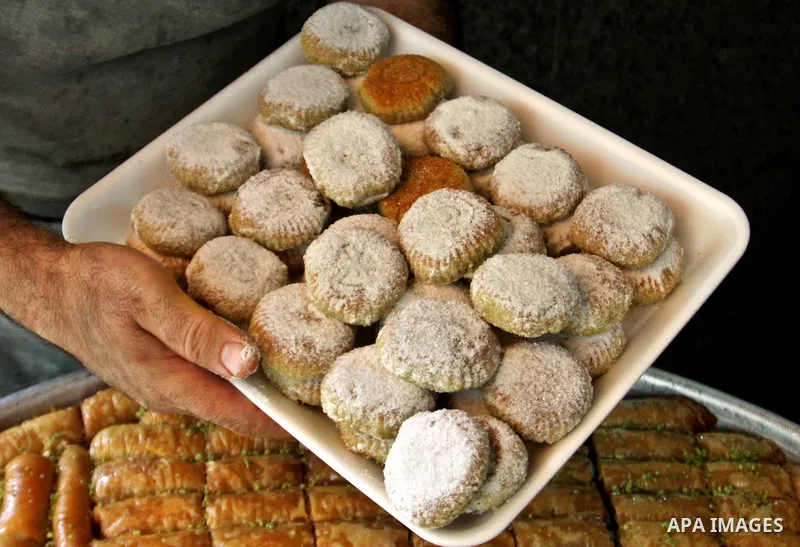 A Palestinian vendor displays his goods "traditional nut cookies" before the upcoming Eid al-Fitr holidays at a bakery in the West Bank city of Nablus, on Aug. 14, 2012. Muslims will celebrate Eid al-Fitr that marks the...