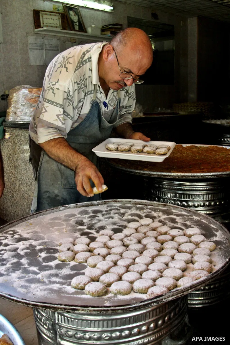 Palestinians vendor make traditional nut cookies before the upcoming Eid al-Fitr holidays at a bakery in the West Bank city of Nablus, on Aug. 14, 2012. Muslims will celebrate Eid al-Fitr that marks the end of the fastin...