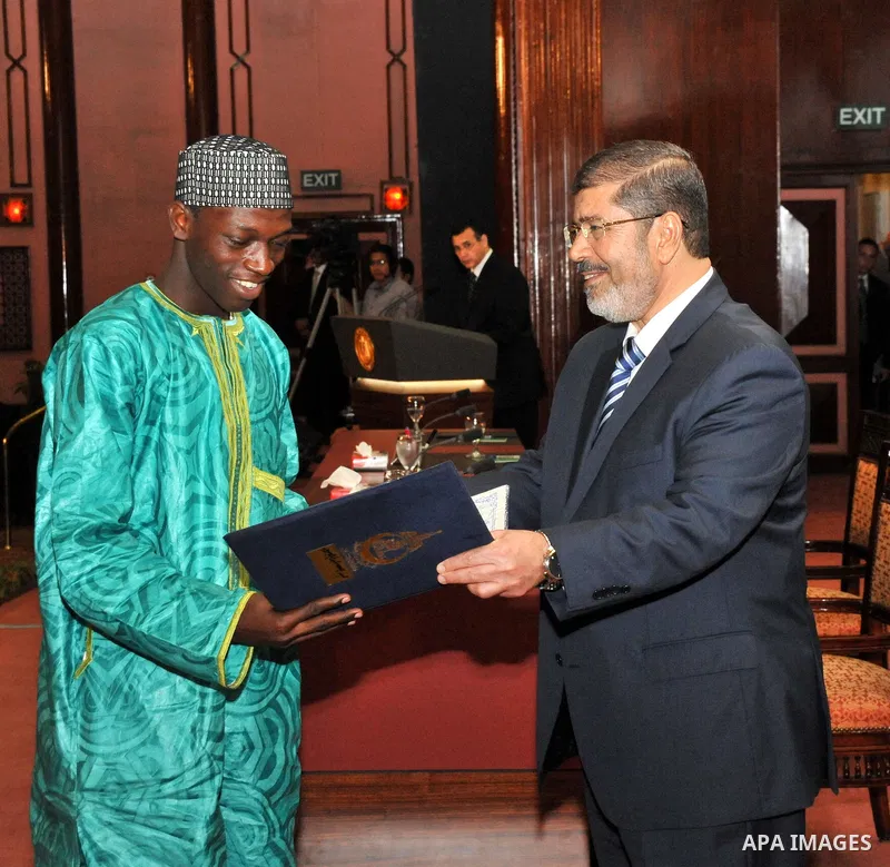 Egypt's President Mohamed Mursi, presents a prize to a youth who won the Conservation of the Holy Koran contest during the Laylat al-Qadr at Egypt Al-Azhar Conference Center at Nasr City in Cairo August 12, 2012. Egypt's...