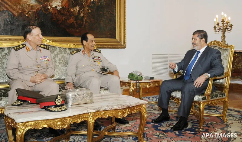 Egyptian president Mohamed Morsi (R) meeting with retired former Defence Minister and Field Marshall Hussein Tantawi (C), and retired Armed Forces Chief of Staff, Sami Anan (L) at the presidential palace in Cairo on Augu...