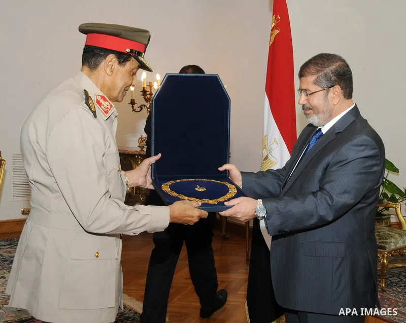 Former Defense Minister Hussein Tantawi, left, receives a high medal from Egyptian President Mohammed Morsi at the Presidential Palace in Cairo, Egypt, Tuesday, Aug. 14, 2012. Egypt's president has given awards to the na...