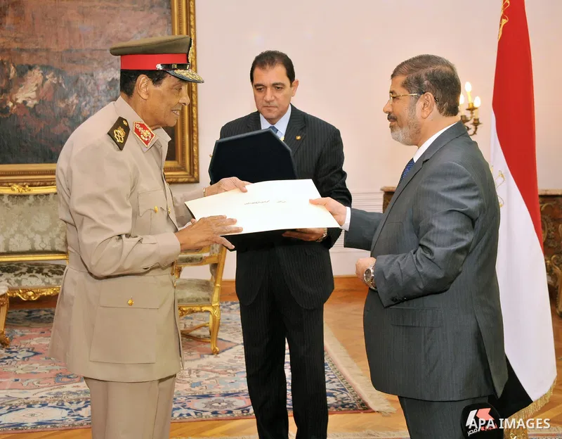 Former Defense Minister Hussein Tantawi, left, receives a high medal from Egyptian President Mohammed Morsi at the Presidential Palace in Cairo, Egypt, Tuesday, Aug. 14, 2012. Egypt's president has given awards to the na...
