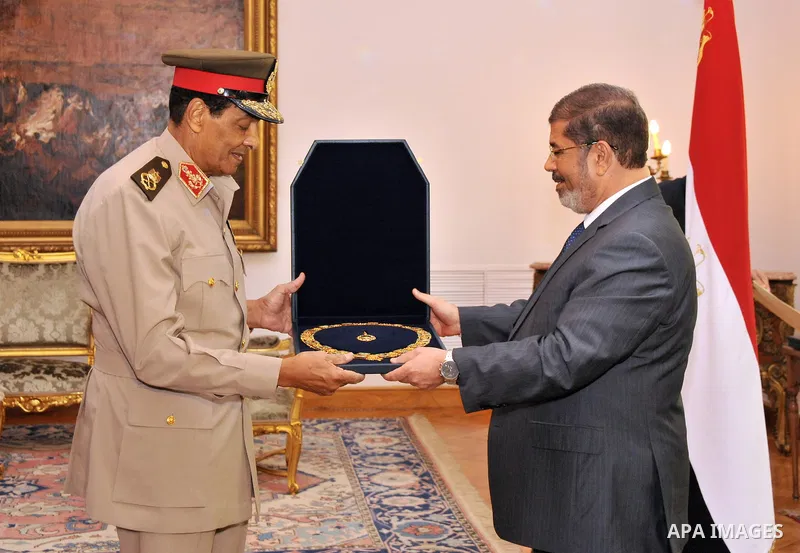 Former Defense Minister Hussein Tantawi, left, receives a high medal from Egyptian President Mohammed Morsi at the Presidential Palace in Cairo, Egypt, Tuesday, Aug. 14, 2012. Egypt's president has given awards to the na...