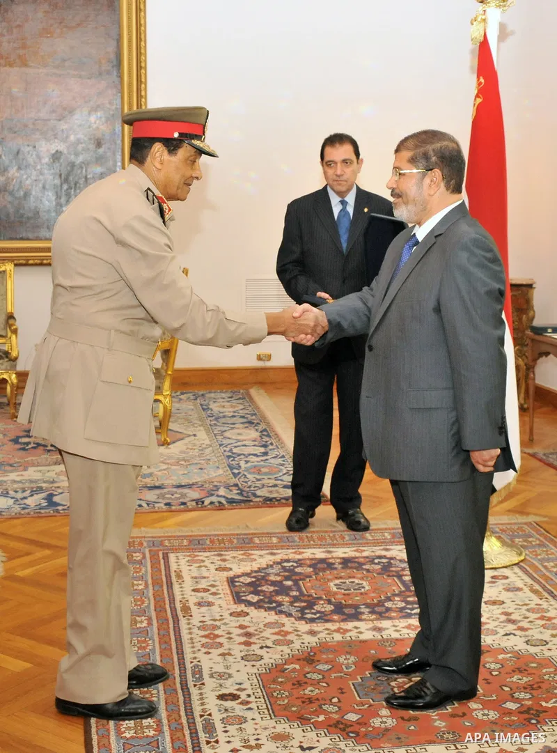 Former Defense Minister Hussein Tantawi shakes hands with Egyptian President Mohammed Morsi at the Presidential Palace in Cairo, Egypt, Tuesday, Aug. 14, 2012. Egypt's president has given awards to the nation's two top m...