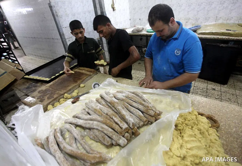 Palestinian workers make traditional date-filled cookies in preparation for the Eid al-Fitr holiday at bakery in the Gaza Strip on August 16, 2012. Muslims around the world are preparing to celebrate the Eid al-Fitr holi...