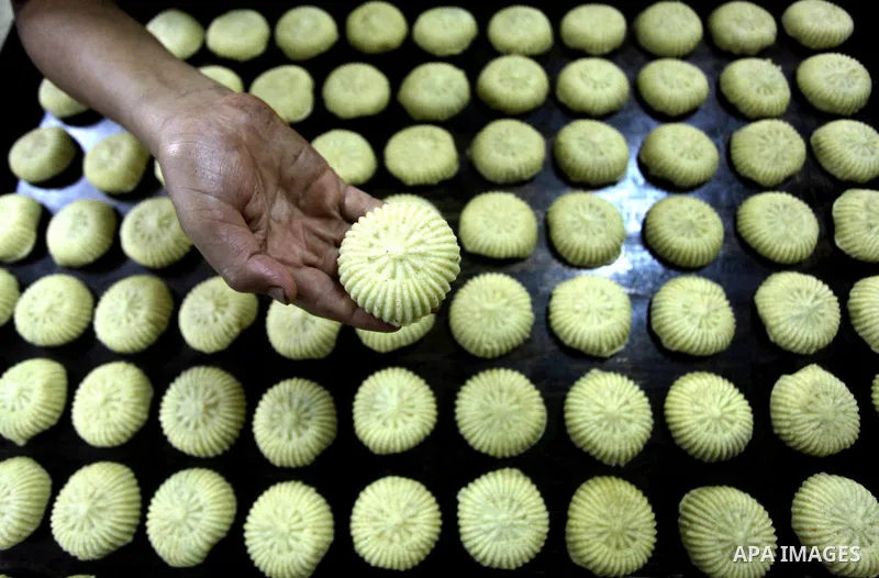 Palestinian workers make traditional date-filled cookies in preparation for the Eid al-Fitr holiday at bakery in the Gaza Strip on August 16, 2012. Muslims around the world are preparing to celebrate the Eid al-Fitr holi...