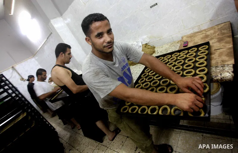 Palestinian workers make traditional date-filled cookies in preparation for the Eid al-Fitr holiday at bakery in the Gaza Strip on August 16, 2012. Muslims around the world are preparing to celebrate the Eid al-Fitr holi...