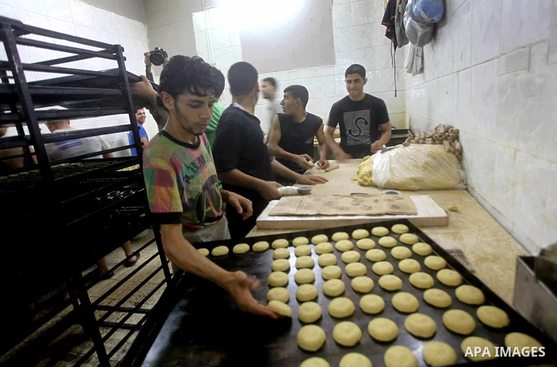 Palestinian workers make traditional date-filled cookies in preparation for the Eid al-Fitr holiday at bakery in the Gaza Strip on August 16, 2012. Muslims around the world are preparing to celebrate the Eid al-Fitr holi...