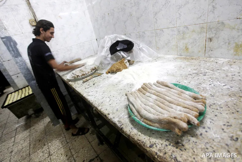 Palestinian workers make traditional date-filled cookies in preparation for the Eid al-Fitr holiday at bakery in the Gaza Strip on August 16, 2012. Muslims around the world are preparing to celebrate the Eid al-Fitr holi...