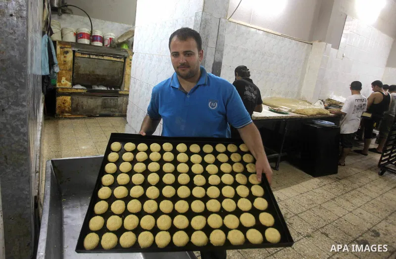 Palestinian workers make traditional date-filled cookies in preparation for the Eid al-Fitr holiday at bakery in the Gaza Strip on August 16, 2012. Muslims around the world are preparing to celebrate the Eid al-Fitr holi...