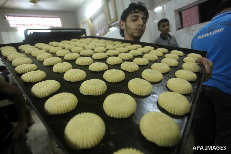 Palestinian workers make traditional date-filled cookies in preparation for the Eid al-Fitr holiday at bakery in the Gaza Strip on August 16, 2012. Muslims around the world are preparing to celebrate the Eid al-Fitr holi...