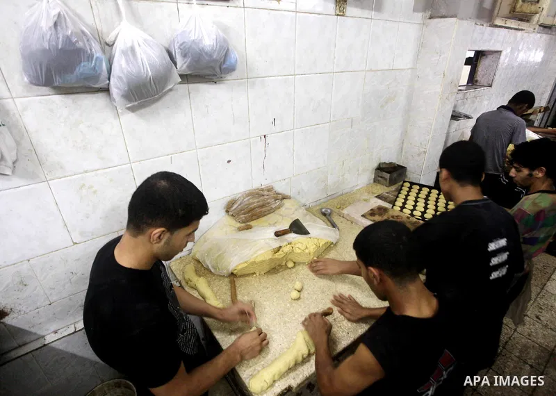 Palestinian workers make traditional date-filled cookies in preparation for the Eid al-Fitr holiday at bakery in the Gaza Strip on August 16, 2012. Muslims around the world are preparing to celebrate the Eid al-Fitr holi...