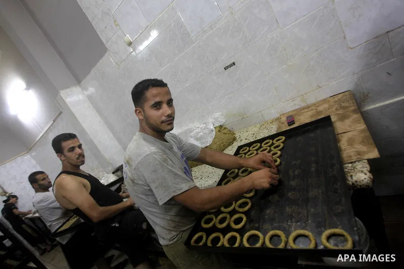 Palestinian workers make traditional date-filled cookies in preparation for the Eid al-Fitr holiday at bakery in the Gaza Strip on August 16, 2012. Muslims around the world are preparing to celebrate the Eid al-Fitr holi...