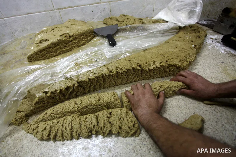 Palestinian workers make traditional date-filled cookies in preparation for the Eid al-Fitr holiday at bakery in the Gaza Strip on August 16, 2012. Muslims around the world are preparing to celebrate the Eid al-Fitr holi...
