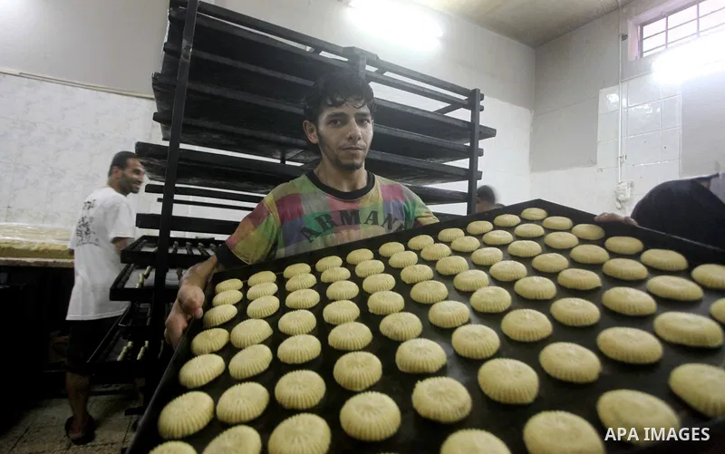 Palestinian workers make traditional date-filled cookies in preparation for the Eid al-Fitr holiday at bakery in the Gaza Strip on August 16, 2012. Muslims around the world are preparing to celebrate the Eid al-Fitr holi...