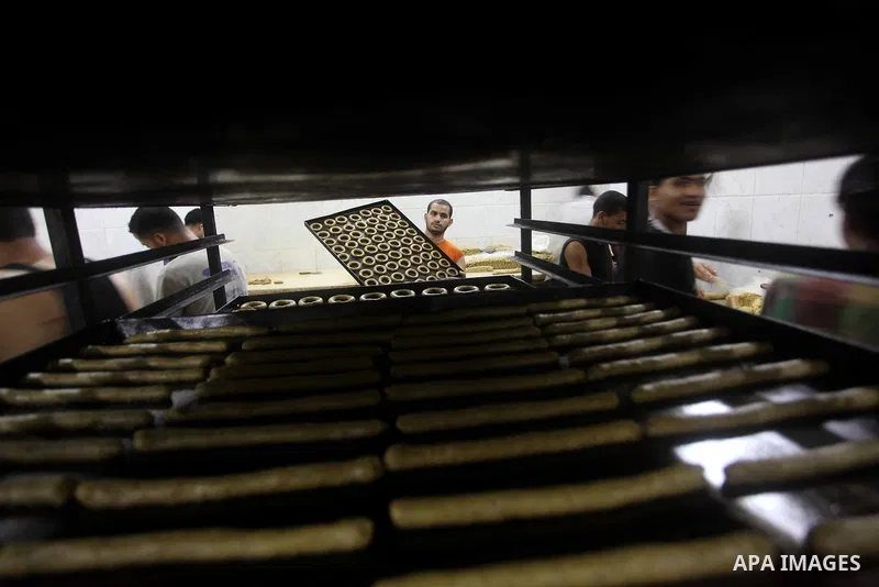 Palestinian workers make traditional date-filled cookies in preparation for the Eid al-Fitr holiday at bakery in the Gaza Strip on August 16, 2012. Muslims around the world are preparing to celebrate the Eid al-Fitr holi...
